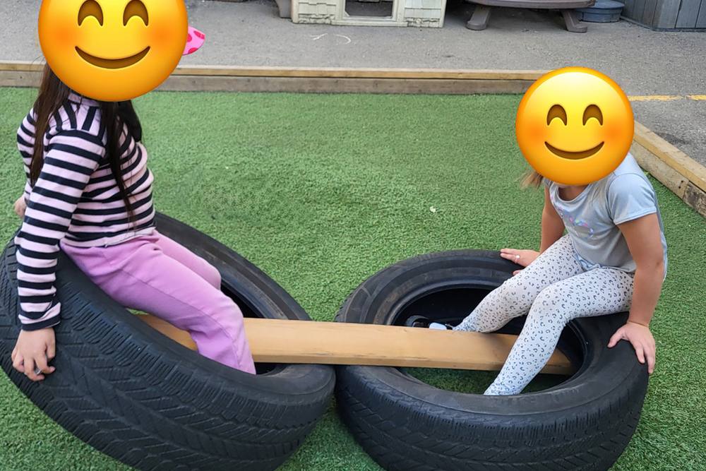 Children balancing on a tire seesaw