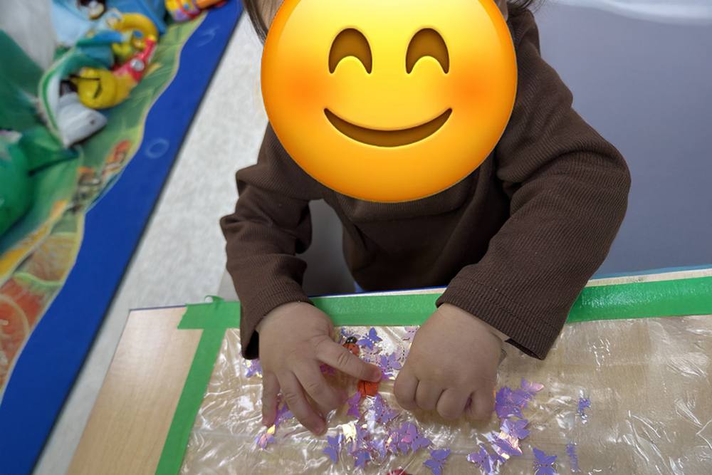 Baby exploring a taped-down sensory activity