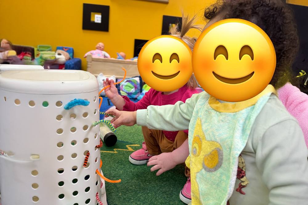 Babies threading pipe cleaners through a laundry basket