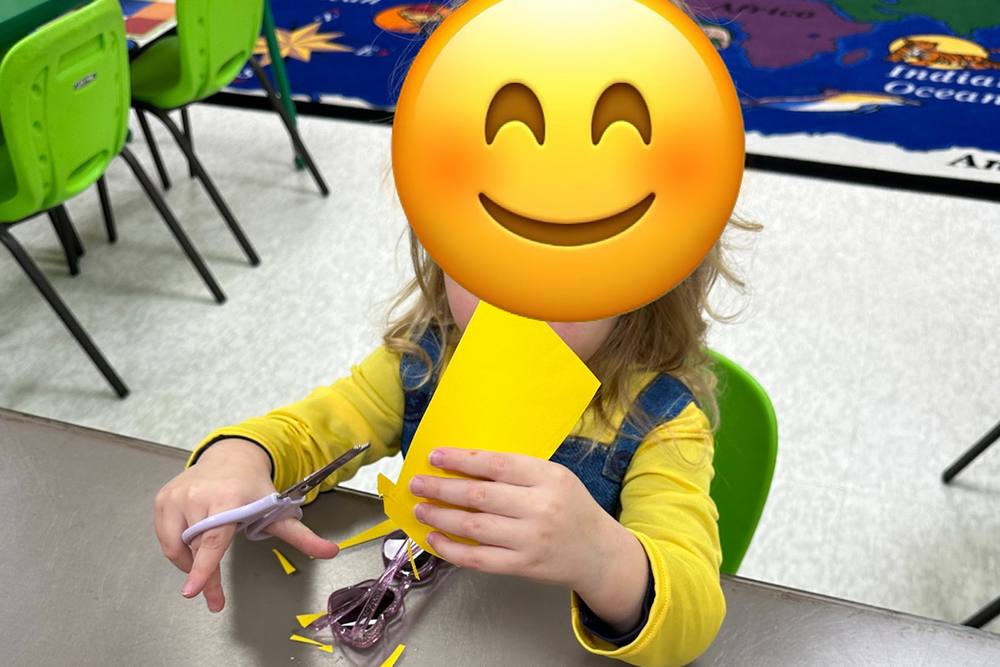 Preschooler cutting paper with scissors