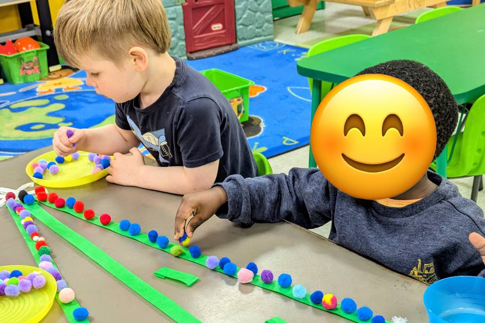 Preschoolers placing pom-poms along a line