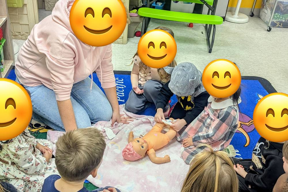 Preschoolers caring for baby dolls during pretend play